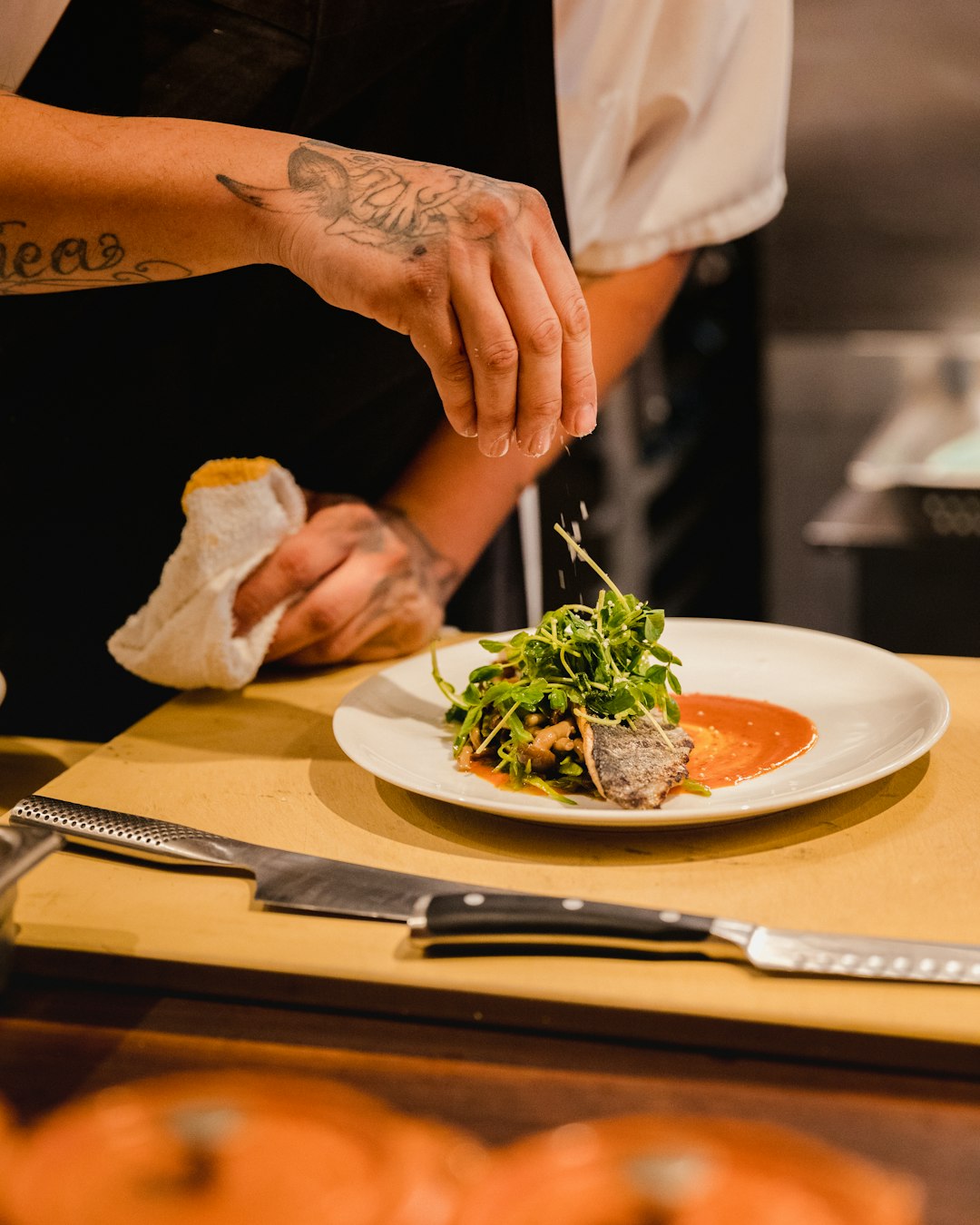 Mains d'un chef dressant une assiette